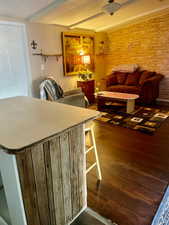 Living area featuring dark wood-type flooring and beam ceiling