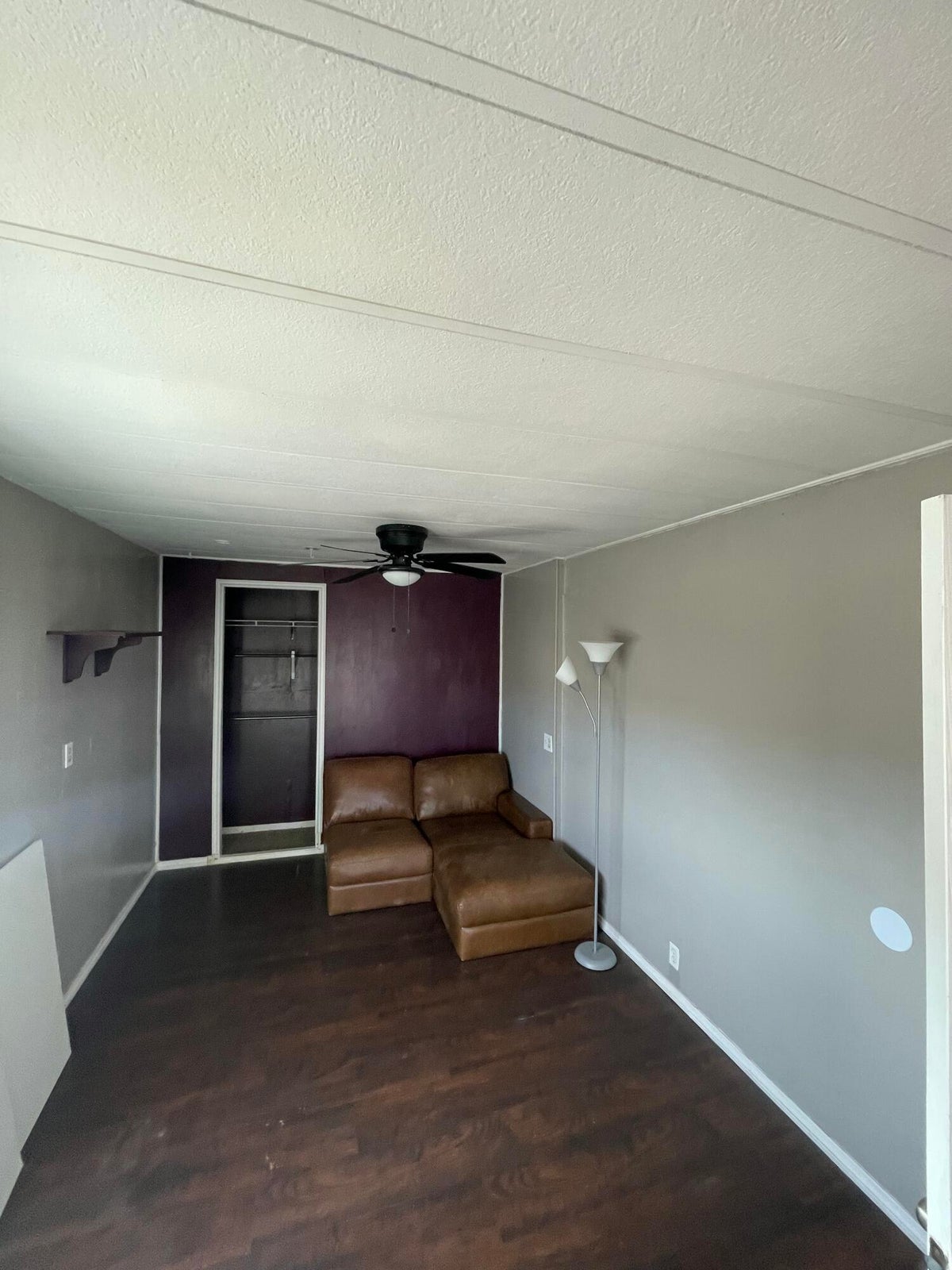 Unfurnished room with dark wood-type flooring, a textured ceiling, and a ceiling fan