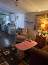 Living area featuring dark wood finished floors and beamed ceiling