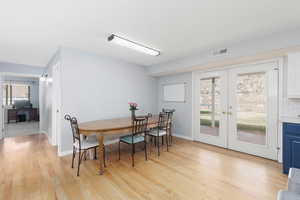 Dining room featuring french doors, light wood-style flooring, and plenty of natural light