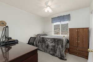 Bedroom with a ceiling fan and light carpet