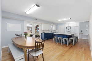 Dining area with light wood finished floors and french doors