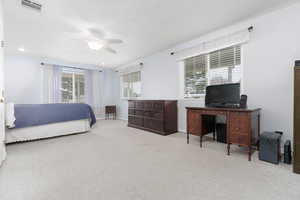 Bedroom featuring light colored carpet, a ceiling fan, and recessed lighting
