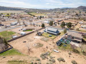 Aerial view of property and surrounding area featuring a mountainous background and nearby suburban area