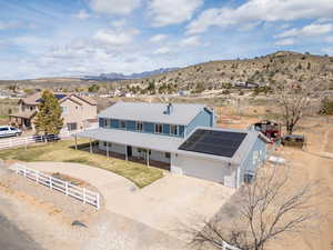 View of front of property featuring roof mounted solar panels, a metal roof, driveway, a mountain view, and a porch