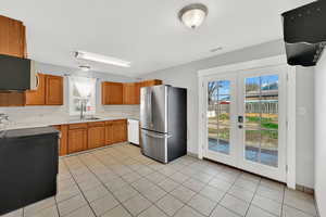 Kitchen with several new appliances and sink/faucet. View of dining space