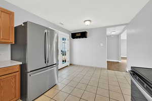 Kitchen with several new appliances and sink/faucet. View of dining space