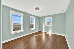 Bedroom with closet and hardwood flooring, this room has pull down blinds.