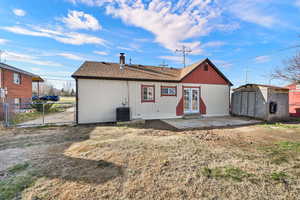 Back of house with patio, shed, and view of parking/fence