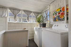 Laundry area with tile walls and washing machine and clothes dryer