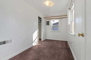 Empty room featuring dark carpet