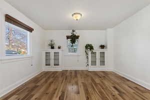 Unfurnished living room featuring light wood-style floors and baseboards