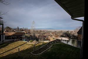 Fenced backyard with a trampoline, a balcony, and a residential view
