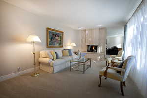 Carpeted living area with a premium fireplace and baseboards