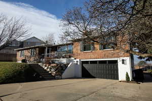 View of front facade featuring an attached garage, brick siding, and driveway