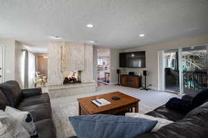 Carpeted living area with a textured ceiling and recessed lighting