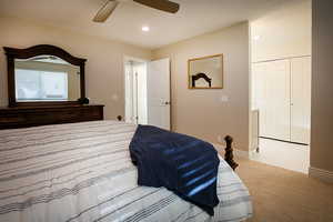 Bedroom with light colored carpet, a textured ceiling, recessed lighting, ceiling fan, and a closet