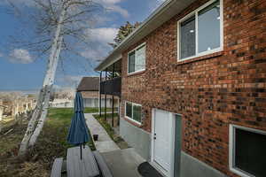 View of side of home with brick siding and a patio area
