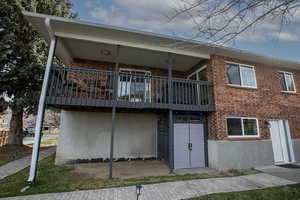 Rear view of property featuring brick siding and a balcony