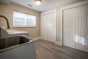 Laundry area with light wood-style floors and independent washer and dryer