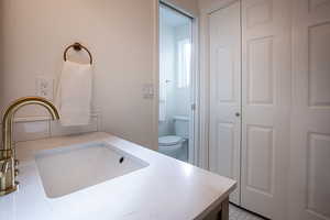 Bathroom with vanity and a closet