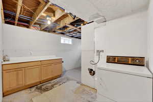Laundry area with washer / clothes dryer and unfinished concrete floors