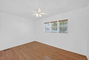 Unfurnished room featuring a ceiling fan and wood finished floors