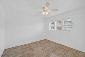 Empty room featuring wood finished floors and a ceiling fan