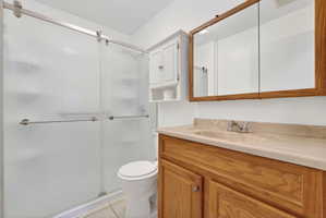 Full bathroom with vanity, a shower stall, and light tile patterned floors