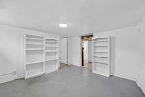Unfurnished bedroom with a textured ceiling, a closet, and finished concrete floors