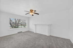 Unfurnished living room with carpet flooring and ceiling fan