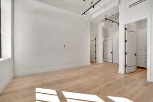 Spare room with light wood-type flooring and rail lighting