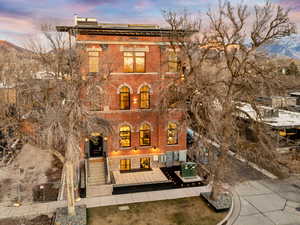 Italianate-style house with roof mounted solar panels, a mountain view, and brick siding