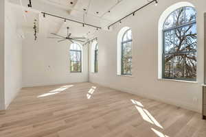 Spare room with rail lighting, light wood finished floors, and ceiling fan