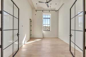 Unfurnished bedroom with light wood-style flooring, a ceiling fan, and french doors