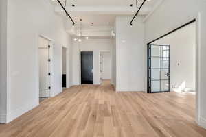 Spare room with a high ceiling and light wood-type flooring