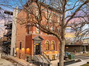 Back of house with a gate, brick siding, and a fenced front yard