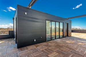 Back of house with a patio area and a mountain view