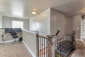 Office with carpet floors and a textured ceiling
