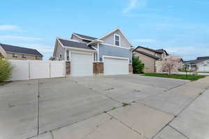 View of home's exterior with a gate, driveway, a residential view, stone siding, and a garage