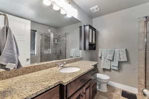 Bathroom with a shower stall, vanity, and light tile patterned flooring