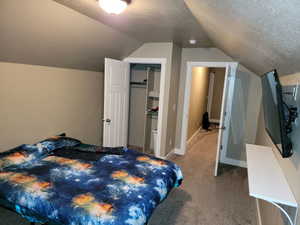 Carpeted bedroom with a textured ceiling and a closet