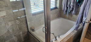 Full bath featuring a garden tub and a stall shower