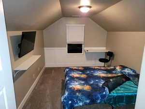 Bedroom featuring dark carpet and a textured ceiling