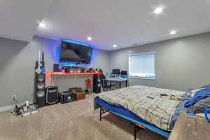 Carpeted bedroom featuring an office area and recessed lighting