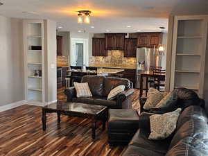 Living area featuring dark wood-style floors and recessed lighting