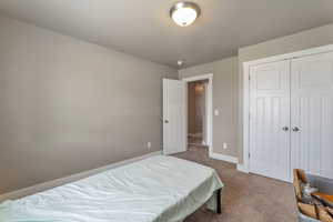 Bedroom featuring carpet flooring and a closet