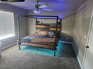 Carpeted bedroom featuring a ceiling fan and baseboards