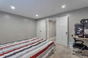 Bedroom featuring light carpet, recessed lighting, an office area, and a closet