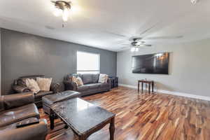 Living room featuring ceiling fan and wood finished floors